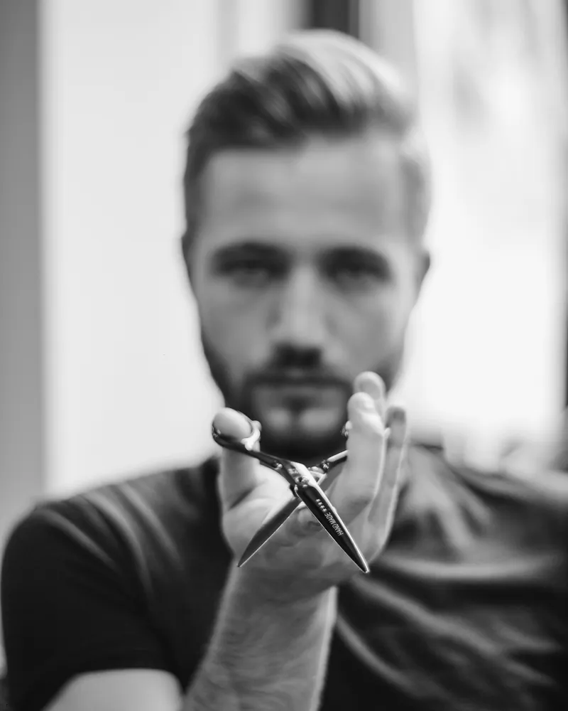 Barber One holding scissors, black and white portrait