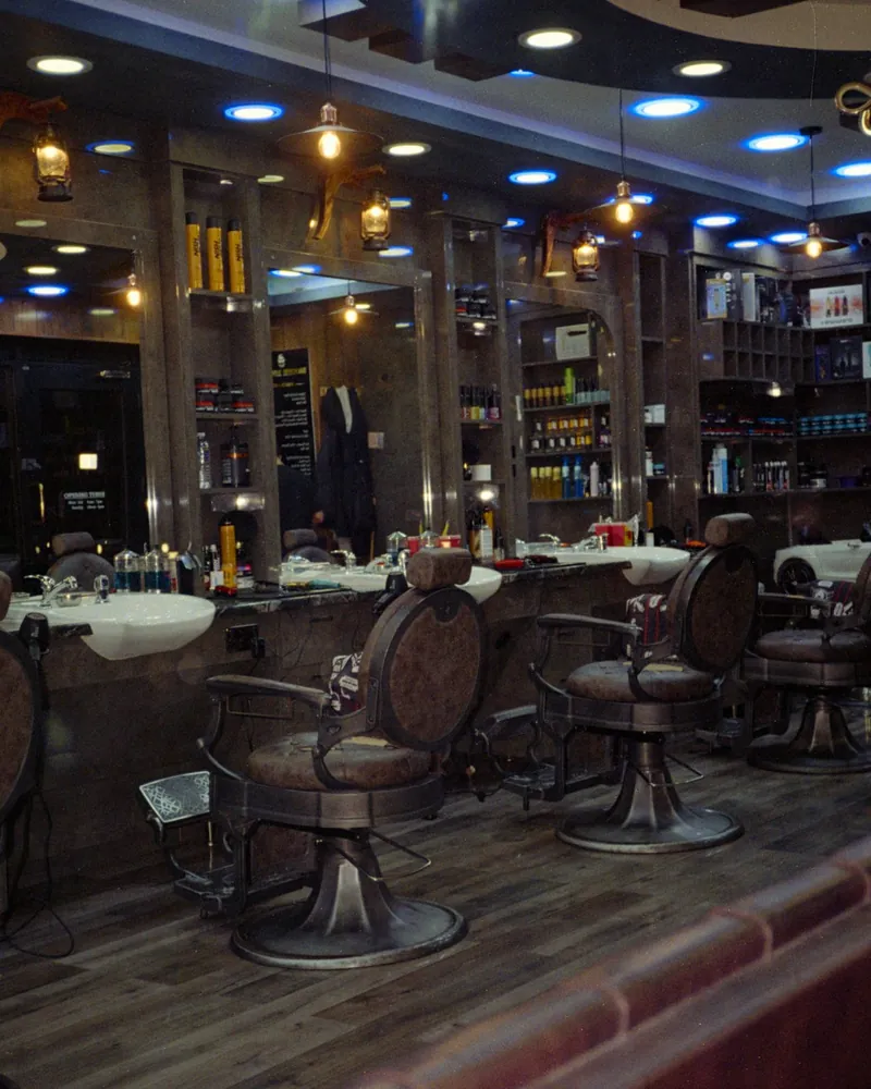 Empty shop floor with leather barber chairs and mirrors